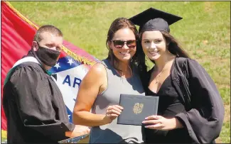  ??  ?? After their names
were called by Jones, Gravette students picked up their diplomas and stopped for a photo with a parent or guardian on Sunday afternoon in Lion Stadium. Kharli Furlow poses with her mother after receiving her diploma.