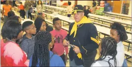  ??  ?? Hardrick Crawford of the Greater Washington D.C. Chapter of the 9th and 10th (Horse) Cavalry Associatio­n shows a replica of a pistol used by “Buffalo Soldiers” in the late 1800s to students at Benjamin Stoddert Middle School.
