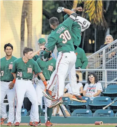  ?? DAVID SANTIAGO/MIAMI HERALD ?? Miami first baseman Alex Toral, an Archbishop McCarthy graduate, is congratula­ted by teammates after hitting a solo home run against Duke during the second inning of a 4-3 victory in Coral Gables on Thursday. UM finished the regular season at 38-17.