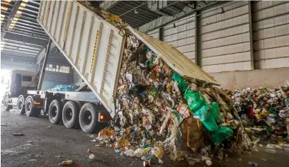  ??  ?? TRANSFORMA­TION STARTS HERE... A truck off loading household waste collected by Tandeef at the material recovery facility of Bee’ah.