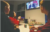  ?? PAUL ELLIS / AFP VIA GETTY IMAGES ?? A family gathers around the telly in Liverpool to watch Prime Minister Boris Johnson give a message to the
nation from 10 Downing Street on Monday.