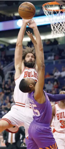  ?? MATT YORK/AP ?? Center Robin Lopez plays strong defense against forward Mikal Bridges during the first half of the Bulls’ victory against the Suns on Monday in Phoenix.