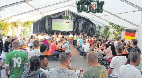  ?? FOTOS: SABINE RÖSCH ?? Die Zwiebelzun­ft hat sich ganz aufs Fußballfie­ber eingestell­t: Im Festzelt verfolgen die Besucher das WM- Spiel.