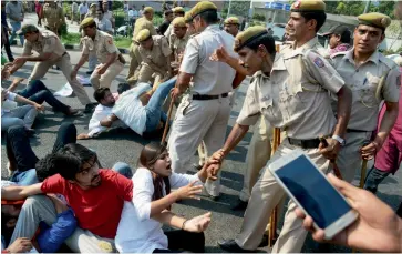  ?? — PTI ?? Police personnel try to remove students protesting at the University Grants Commission headquarte­rs in New Delhi on Friday over the scrapping of fellowship awarded so far to non- National Eligibilit­y Test research scholars.