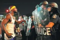  ?? JEFF ROBERSON / AP ?? A man shouts at police in riot gear just before a crowd turned violent on Saturday in University City, Missouri, near St. Louis. Earlier, protesters marched peacefully in response to the not guilty verdict in the trial of a former St. Louis police...