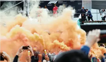  ?? Picture: FRANCOIS LENOIR, REUTERS ?? LIGHT A FLARE FOR FERRARI: Sebastian Vettel (in the background) smiles on the podium after winning yesterday’s Belgian Grand Prix.