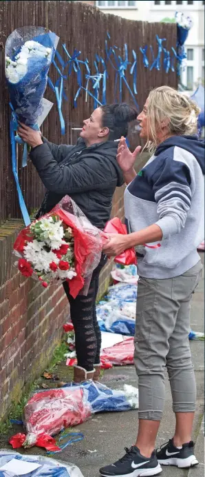  ??  ?? Tribute to a criminal: Grieving family and friends of burglar Henry Vincent attach flowers to a fence near the house where he died