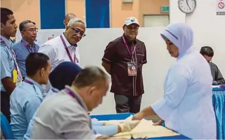  ?? BERNAMA PIC ?? Election Commission deputy chairman Tan Sri Othman Mahmood (second from right) visiting the early voting centre for the Seri Setia by-election at Ababil Multipurpo­se Hall in the Subang Airbase, Subang, yesterday.