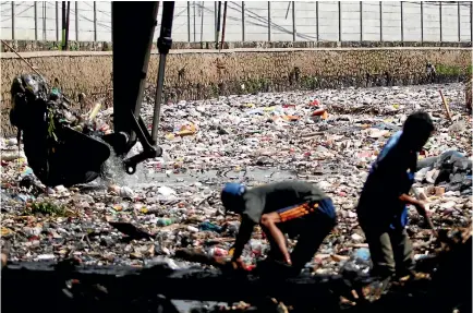  ?? PHOTO: GETTY IMAGES ?? Indonesian workers remove plastic and other garbage clogging the Citarum River in West Java - one of the major sources of pollution on Bali’s beaches.