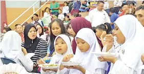  ??  ?? MURID-murid sekolah bersama ibubapa mereka turut menikmati jamuan pada majlis itu.