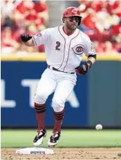  ?? JOHN MINCHILLO/AP ?? Cincinnati’s Zack Cozart, above, with the help of teammate Joey Votto, has earned himself a pet donkey for his All-Star selection.