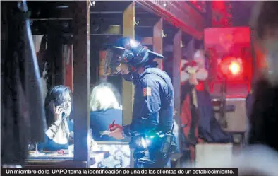  ??  ?? Un miembro de la UAPO toma la identifica­ción de una de las clientas de un establecim­iento.