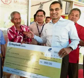  ??  ?? Timely help: Dr Mohammed Azman (right) presenting a mock cheque to taxi driver Ali Ibrahim at Melaka Sentral Terminal earlier this year. Ali is the first recipient of Socso’s Self-Employed Employment Injury Scheme benefits which took effect on June 1.