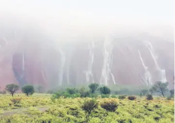  ??  ?? Waterfalls caused by heavy rain run down the side of Australia’s famous Uluru rock formation in central Australia. — Reuters photo