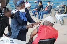  ?? African News Agency (ANA) JACQUES NAUDE ?? A MAN receives his vaccine at the Saulsville Arena vaccinatio­n site. |