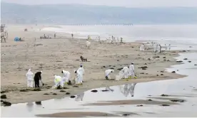  ?? Frederic J Brown/AFP/Getty Images ?? Cleanup crew works on the beach in Newport Beach, California, on 7 October. Photograph: