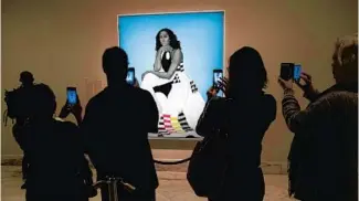  ?? JOSE LUIS MAGANA/AP ?? Visitors take pictures of the official portrait of former first lady Michelle Obama at the Smithsonia­n’s National Portrait Gallery in 2018.