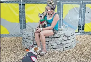  ??  ?? DELORAS SULLIVAN holds her dog La-La at the park, which opens amid a consensus that shelters’ pet bans are a barrier to helping L.A.’s 53,000 homeless people turn their lives around.