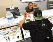  ?? ETHAN MILLER / GETTY IMAGES 2017 ?? An employee shows a customer cannabis products at Essence Vegas Cannabis Dispensary in Las Vegas. Recreation­al marijuana sales in Nevada began July 1, 2017.