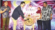  ??  ?? Ling hitting the gong to officiate at the event as Zulkefli (right) and Saiful (left) look on.