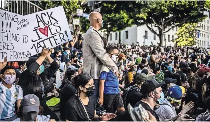  ?? BRYAN DENTON PARA THE NEW YORK TIMES ?? Una multitud de manifestan­tes contempla un minuto de silencio en una protesta en Los Ángeles.