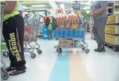  ?? BRENDAN SMIALOWSKI, AFP/GETTY IMAGES ?? Shoppers stock up on supplies at a Food Town grocery store Friday in Houston.