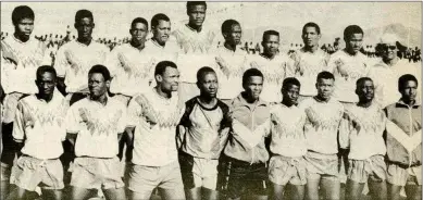  ?? ?? The three musketeers...Albert (4th), Bimbo (8th), Jamanuka (9th) from left - back row), with Liverpool FC. The trident was the pillar of the now-defunct exciting Nau-Aib (Okahandja) outfit Liverpool FC. Standing from left: Willem Kapukare, Marks Somseb, Killian Kavari, Albert Tjihero, Hellao Naruseb, Stimela Stephanus, Donaldt Tjikune, Bimbo Tjihero, Jamanuka Tjihero, Bobby Sissing (team manager - d+). Kneeling from left: China Utoni, Kamitiri Kuuahee, Dawid Snewe, Toufi Mbako, Norii Kaanjuka, Malombo Kawena, India Katjivena, Mbakero Jaezuruka, Sylvanus Ndjambari (d+).