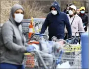  ?? SEAN MCKEAG — THE CITIZENS’ VOICE VIA AP ?? Customers enter and exit the Walmart in Hazle Township, Pa. Saturday, April 4, 2020.