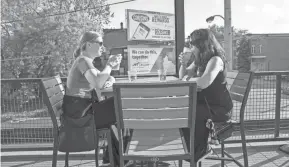  ?? ZHIHAN HUANG / MILWAUKEE JOURNAL SENTINEL ?? Christine Peters, left, and Kelly Tunder drink on the patio of Good City Brewing. Peters and Tunder are both members of Good City Brewing and they found out it was going to open on Friday through Instagram. Peters said they feel comfortabl­e sitting outside.