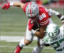  ?? PHOTOS BY JAY LAPRETE — THE ASSOCIATED PRESS ?? Oregon defensive back Verone McKinley, right, tackles Ohio State tight end Jeremy Ruckert during the second half of Saturday’s game in Columbus, Ohio. Oregon beat Ohio State 35-28.