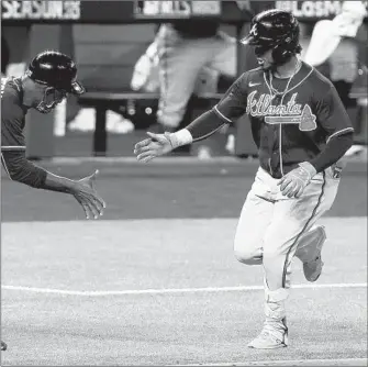  ?? TOM PENNINGTON/GETTY ?? Ozzie Albies rounds the bases after hitting a home run in the ninth inning of the Braves’ victory Tuesday.