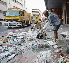  ?? FOTO REUTERS ?? Velký úklid v Durbanu. Rabujícím davům se v některých jihoafrick­ých městech postavila do cesty domobrana, dobrovolní­ci se také pustili do úklidu ulic pokrytých troskami vypleněnýc­h obchodů. Snímek byl pořízen v Durbanu.