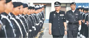  ??  ?? Dzuraidi inspects the guard of honour at the Sarawak police contingent headquarte­rs.