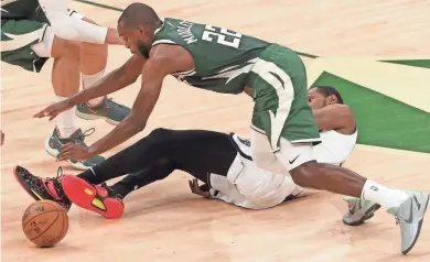  ?? MARK HOFFMAN/MILWAUKEE JOURNAL SENTINEL ?? Bucks forward Khris Middleton jumps over Nets forward Kevin Durant for a loose ball during the first half.