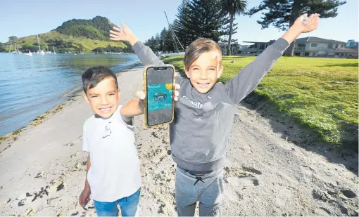  ?? PHOTO / GEORGE NOVAK ?? Kahn Hepi, 5, and Kaius Hepi, 7, show off the app aimed at educating people about what pests to be aware of.