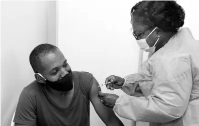  ?? NATHANIEL STEWART/ PHOTOGRAPH­ER ?? Olufunke Adetola, senior public heath nurse, administer­s the COVID-19 shot to Clarendon police commander, Senior Superinten­dent Glenford Miller, at a vaccinatio­n site in May Pen on Tuesday.