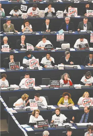  ?? FREDERICK FLORIN AGENCE FRANCE-PRESSE ?? Les membres du Parlement européen, certains affichant des slogans contre l’accord, au moment du vote sur l’AECG