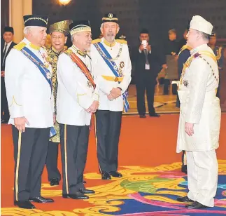  ??  ?? Sultan Muhammad V having a brief conversati­on with Mohamad Asfia (second left) in conjunctio­n with the 244th (Special) Meeting of the Conference of Rulers pertaining to the swearing-in and signing of the instrument of office of the 15th Yang di-Pertuan...