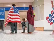  ?? Mark Mulligan/Staff file photo ?? An Afghan family waits for the elevator after being greeted by volunteers last year at Bush airport.