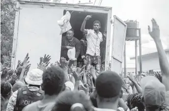  ?? RICHARD PIERRIN Getty Images ?? After the Aug. 14 earthquake, Haitian residents in Les Cayes wait to receive humanitari­an aid from the Fund for Economic and Social Assistance.