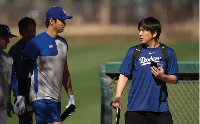  ?? (AP Photo/ Carolyn Kaster, File) ?? Los Angeles Dodgers’ Shohei Ohtani walks with interprete­r Ippei Mizuhara Feb. 12 at batting practice during spring training baseball workouts in Phoenix. The former longtime interprete­r for Los Angeles Dodgers star Shohei Ohtani has been charged with federal bank fraud for crimes involving gambling debts and theft of millions of dollars from the slugger. Federal authoritie­s announced the developmen­t Thursday at a press conference in Los Angeles.