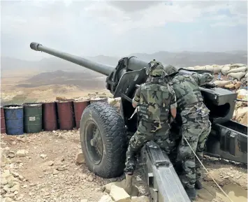  ?? THE ASSOCIATED PRESS FILES ?? Lebanese soldiers are seen with a 130 mm howitzer cannon, pointed at areas controlled by Islamic State militants near Arsal, in northeast Lebanon, on June 19. Lebanon is gearing up for a long awaited assault to dislodge hundreds of militants from a...