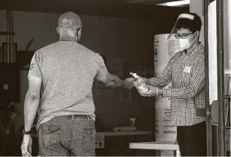  ?? Hadley Chittum / Staff photograph­er ?? A voter gets a handful of sanitizer as he enters the St. Mary’s Catholic Church gym to vote in the runoff election Tuesday. The election was delayed from its original date due to the coronaviru­s.