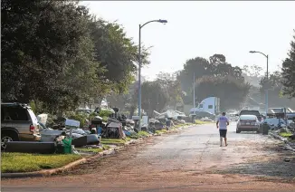  ?? SCOTT OLSON / GETTY IMAGES ?? Debris removed from flooded houses is piles along a street in Houston on Friday. A major challenge after a natural disaster like Hurricane Harvey is removing the massive amounts of trash and finding somewhere to put it. Some household items may contain...