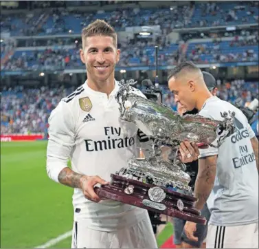  ??  ?? OTRO MÁS A LA VITRINA. Ramos, mostrando el trofeo. Tras el Raúl de Tomás, que no llegó a jugar.