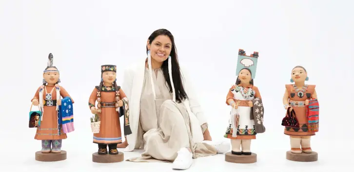  ?? | PHOTOGRAPH­Y BY JASON S. ORDAZ, IAIA ?? Kathleen Wall (Jemez Pueblo) sits with the four figures of Create Our Future—Honor Our Past (2021).