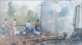  ?? AP PHOTOS ?? (Above) Rescuers try to douse the fire after an explosion at a firecracke­r factory in Balaghat, Madhya Pradesh, on Wednesday and (right) rescuers remove the charred bodies from the spot.