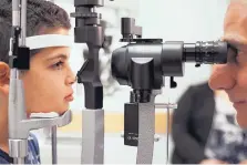  ?? BILL WEST/ASSOCIATED PRESS ?? Dr. Albert Maguire checks the eyes of Misa Kaabali, 8, at the Children’s Hospital of Philadelph­ia after he received his gene therapy.