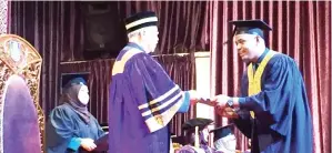  ??  ?? AHMADSHAH (kiri) menyampaik­an ijazah kepada salah seorang graduan pada majlis itu.