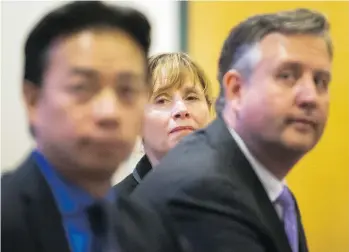  ?? ARLEN REDEKOP ?? Shauna Sylvester listens as she’s seen between rival candidates Ken Sim, left, and Kennedy Stewart at Sunday’s Vancouver mayoral town hall at S.U.C.C.E.S.S. Choi Hall.